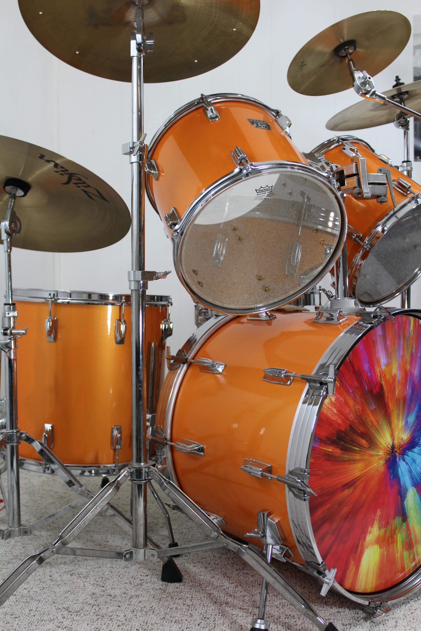 Set of drums painted with bright orange candy.