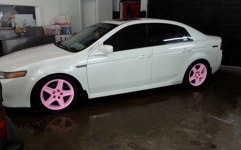 Car with the pink to orange glow in the dark wheels in the light.